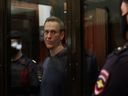 Der russische Oppositionsführer Alexej Nawalny steht während der Anhörung vor dem Moskauer Stadtgericht in einem Glaskäfig.  Er wird für die Strafe inhaftiert, die er 2014 wegen einer Verurteilung wegen Betrugs erhalten hat.