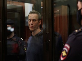 Russian opposition leader Alexei Navalny stands in a glass cage during the hearing in the Moscow City Court. He will be imprisoned for the sentence he received in 2014 for a fraud conviction.