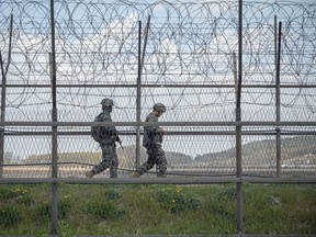 South Korean soldiers patrol on April 23, 2020, the barbed wire fence at the Demilitarized Zone separating North and South Korea, on the South Korean island of Ganghwa.