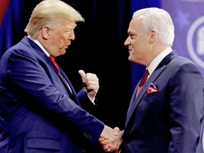 On February 29, 2020, then president Donald Trump (L) shakes hands with Matt Schlapp, chairman of the American Conservative Union, at the Conservative Political Action Conference in Oxon Hill, Maryland, U.S.