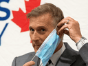 People's Party of Canada Leader Maxime Bernier removes a mask as he arrives for a news conference in Ottawa, August 24, 2020.