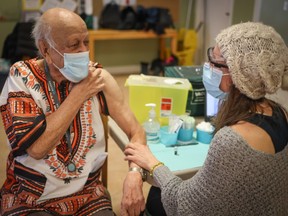 Abdul Makalai, 86, receives a shot of the COVID-19 vaccine at Silvera Aspen in Calgary, Alberta.