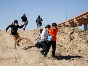 Migrants from Central America flee the Mexican National Guard in Ciudad Juarez, on February 5, 2021, to cross the Rio Bravo and request asylum in El Paso, Texas.