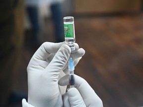 A medical worker prepares to inoculate a police personnel with a Covid-19 coronavirus vaccine at the Police headquarters in Srinagar on January 4, 2021.