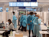 Healthcare workers wait for airline passengers at a COVID-19 testing center at Trudeau Airport in Montreal, Friday, Feb. 19, 2021.