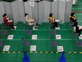 Participants in a mock inoculation exercise wait their turn, as Japan prepares for coronavirus disease (COVID-19) vaccination campaign, at a college gym in Kawasaki,  Japan, January 27, 2021.