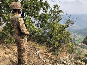 A Pakistan army soldier stands guard on the Line of Control (LoC) at Abdullah Pur village in Bhimber district of Pakistani-controlled Kashmir on Feb. 5, 2021.