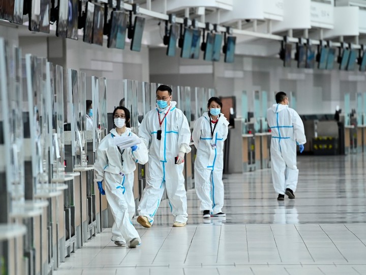  Workers mill about at a check-in counter at Pearson International airport during the COVID-19 pandemic in Toronto on Wednesday, Oct. 14, 2020.