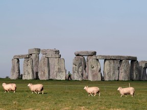 In this file photo sheep graze as security guards patrol the prehistoric monument at Stonehenge in southern England, on April 26, 2020, closed during the national lockdown due to the novel coronavirus COVID-19 pandemic.