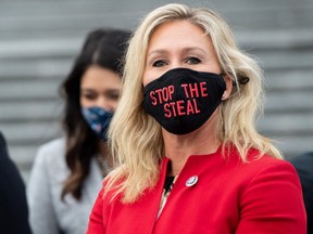 In this file photo taken on January 4, 2021 US Representative Marjorie Taylor Greene, Republican of Georgia, holds up a "Stop the Steal" mask while speaking with fellow first-term Republican members of Congress on the steps of the US Capitol in Washington, DC.