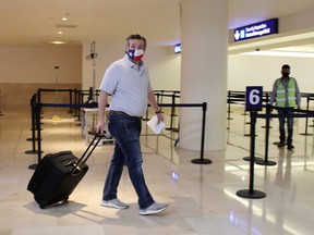 U.S. Senator Ted Cruz carries his luggage at the Cancun International Airport before boarding his plane back to the U.S., in Cancun, Mexico February 18, 2021.