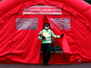 A police volunteer in Woking, southwest of London, exits a briefing on the rollout of test kits to detect the South African variant of COVID-19, on February 2, 2021.