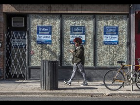 A pedestrian wearing a mask walks past a shuttered business now for lease on Toronto's Queen Street during the Covid 19 Pandemic, Wednesday March 24, 2021.