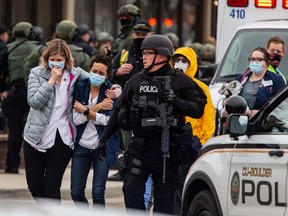 Healthcare workers walk out of a King Sooper's Grocery store after a gunman opened fire