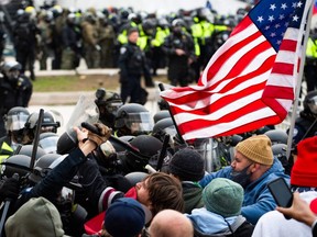 Supporters of U.S. President Donald Trump fight with riot police outside the Capitol building on January 6, 2021 in Washington, DC.