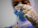 An Egyptian medical worker administers a dose of the Oxford-AstraZeneca COVID-19 vaccine on March 4, 2021, in Cairo on the first day of vaccination in Egypt. 