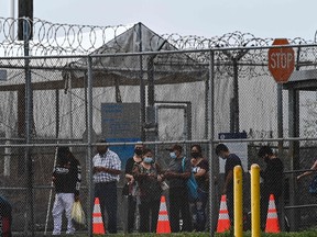 Migrants mostly form Central America wait in line to cross the border into the US at the Gateway International Bridge, between the cities of Brownsville, Texas, and Matamoros, Mexico, on March 15, 2021, in Brownsville, Texas. It's the new normal for migrant families under President Joe Biden, after the harsh "zero tolerance" approach of Donald Trump dashed the dreams of hundreds of thousands hoping to escape endemic poverty and violence in Central America. Biden's pledge of a more humane approach though has sparked a new rush to the border, threatening to become a huge political liability. Republicans are accusing him of opening the country's doors to illegal border-crossers and sparking a "crisis" on the US-Mexico frontier, marked in Texas by the meandering Rio Grande river.