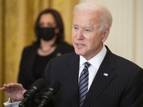 U.S. President Joe Biden speaks while delivering an address as U.S. Vice President Kamala Harris, left, listens in the East Room of the White House in Washington, D.C., U.S., on Thursday, March 18, 2021. Biden announced the U.S. on Friday will clinch his goal of administering 100 million Covid-19 vaccine shots in the first 100 days of his presidency, reaching the mark six weeks ahead of time.