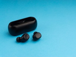 Wireless earbuds or earphones on blue background