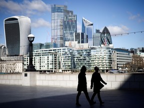 The City of London financial district can be seen as people walk along the south side of the River Thames, amid the COVID-19 outbreak in London