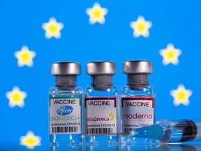 Vials with Pfizer-BioNTech, AstraZeneca, and Moderna coronavirus disease (COVID-19) vaccine labels are seen in front of a European Union (EU) flag in this illustration picture taken March 19, 2021.