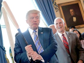 Mike Pence laughs as Donald Trump holds a baseball bat during a Made in America product showcase at the White House in Washington, July 17, 2017.