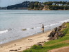 A lone person walks along a beach in Orewa, north of Auckland, on March 5, 2021, as tens of thousands of coastal residents in New Zealand, New Caledonia and Vanuatu fled for higher ground after a tsunami alert.