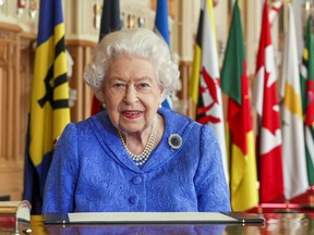 In this image released on March 7, 2021, Queen Elizabeth II signs her annual Commonwealth Day Message in St George's Hall at Windsor Castle, to mark Commonwealth Day, in Windsor, England.