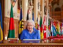 In an undated image released on March 7, 2021, Queen Elizabeth signs her annual Commonwealth Day Message in St. George's Hall at Windsor Castle, to mark Commonwealth Day, in Windsor, England. 