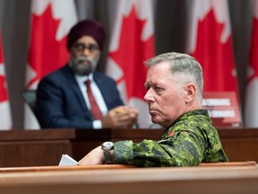 Defence Minister Harjit Sajjan, at rear, attends a press conference in Ottawa with then chief of defence staff Jonathan Vance in a file photo from June 26, 2020. Vance, who was the subject of allegations of inappropriate conduct with female subordinates, retired in January. His replacement, Admiral Art McDonald, has also now stepped down.