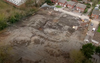 The crater left by the bomb can be seen in the empty field where construction was ongoing.