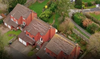 Clay roof tiles can be seen dislodged on nearby houses.