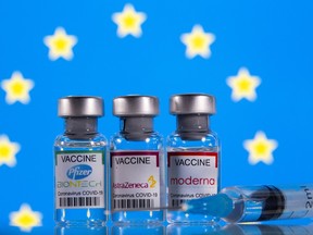 Vials with Pfizer-BioNTech, AstraZeneca, and Moderna coronavirus disease (COVID-19) vaccine labels are seen in front of a European Union (EU) flag in this illustration picture taken March 19, 2021.