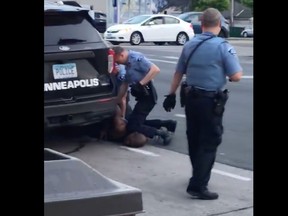In this file still image taken on May 25, 2020, from a video courtesy of Darnella Frazier via Facebook, shows Minneapolis police officer Derek Chauvin (C) arresting George Floyd.