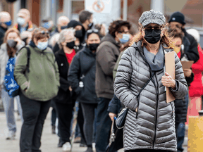 People line up outside of a Shoppers Drug Mart in Toronto for their COVID-19 vaccine on Thursday. Experts say the vaccine offers hope for a quicker return to normal life.