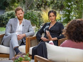 This undated image released March 7, 2021, courtesy of Harpo Productions shows Britain's Prince Harry, left, and his wife Meghan, centre, in a conversation with U.S. television host Oprah Winfrey.