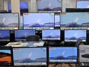 Television screens show file footage of North Korea's missile test as a news program broadcasts reports about North Korea's suspected ballistic missile test, at an electronics mall in Seoul on March 25, 2021.