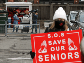 A woman protests outside a Toronto long term care home following a COVID-19 outbreak there, January 10, 2021.