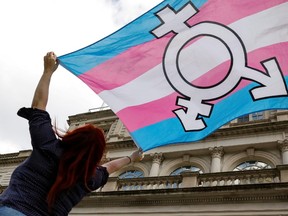 A person holds up an LGBTG flag. A Ohio professor can sue his university for reprimanding him for not addressing a transgender woman by her pronouns.
