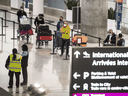 Travellers await transportation to a COVID-19 quarantine hotel after arriving at Toronto's Pearson International Airport, Wednesday February 24, 2021.
