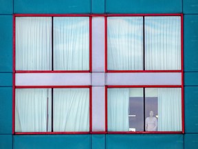A person looks out of a window at a quarantine hotel near Toronto Pearson International Airport in Mississauga on Feb. 24, 2021.