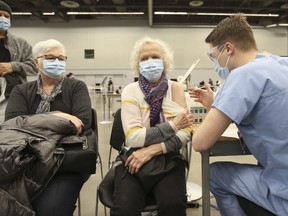 A healthcare worker administers the Pfizer-BioNTech Covid-19 vaccine at the Palais Des Congres convention centre in Montreal, Quebec, Canada, on Monday, March 1, 2021.