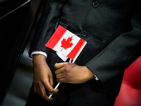Eleven-year-old Ahmed Mohammed holds a flag during a citizenship ceremony ahead of an NHL game on Saturday Jan. 18, 2020.