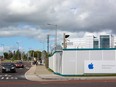An Apple Inc. logo is displayed on a sign in front of hoarding boards as traffic drives past the company's campus in Cork, Ireland, in 2016.