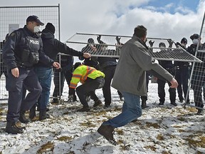 Protesters try to rip down the fencing outside GraceLife Church on Sunday, April 11, 2021.