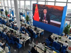 Journalists watch a screen showing China's President Xi Jinping speaking during the Boao Forum for Asia Annual Conference 2021 in Boao, China.