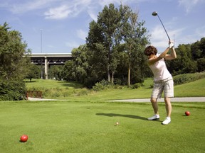 A woman plays golf at the Don Valley Golf Course at Yonge Street and Highway 401 in Toronto.
