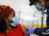 A woman is bandaged after her inoculation by a health worker from Humber River Hospital during a vaccination clinic for residents 18 years of age and older who live in COVID-19 "hot spots" at Downsview Arena in Toronto, Ontario, Canada April 21, 2021.