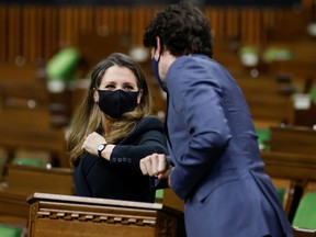 Finance Minister Chrystia Freeland, left, elbow-bumps Prime Minister Justin Trudeau in the House of Commons after she delivered the 2021 federal budget on April 19.