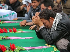 Afghan men gather around the coffins with the headless bodies of a group of Shiite Hazaras — four men, two women and a child — who were beheaded in Ghazni province, on Nov. 10, 2015.  The Hazaras have been persecuted in Afghanistan for over a century.